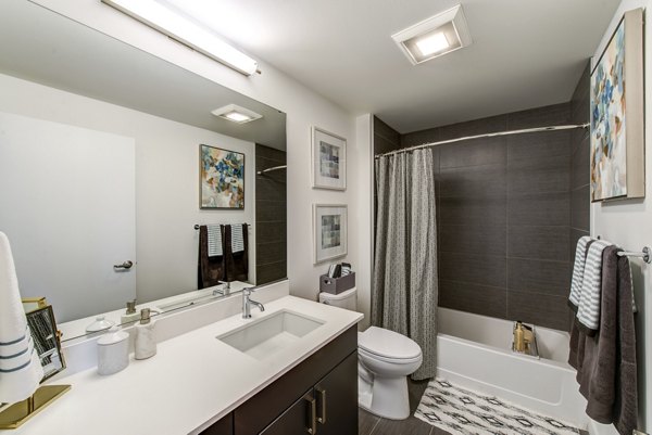 Bright bedroom with blue accent wall, ceiling fan, and large window at Radius Apartments in Greystar community in Berkeley