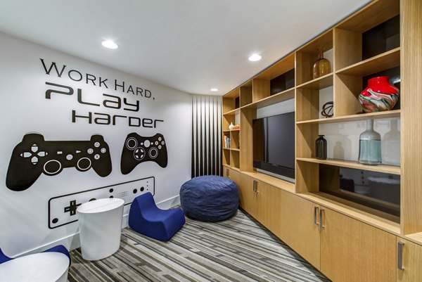 Game room with ping pong table, vibrant stools, and city skyline mural at Radius Apartments Ideal space for socializing and recreation