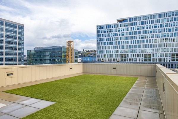 Rooftop patio with seating, fire pit, and city view at Radius Apartments, a luxury community by Greystar in the heart of the city