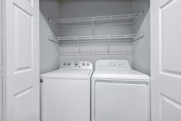 Laundry room with modern appliances and ample storage in Hamilton Ridge Apartments