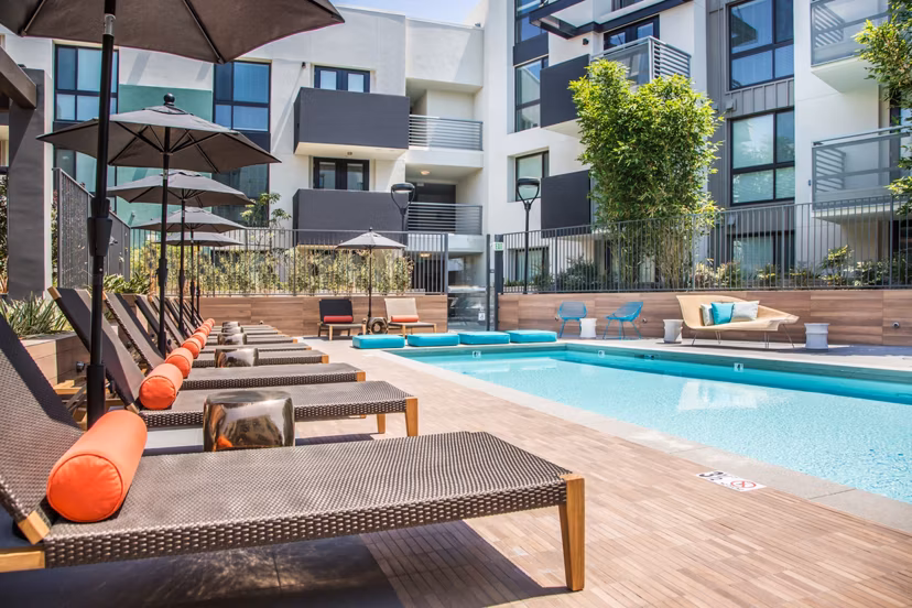 Sunlit outdoor pool with lounge seating at Access Culver City Apartments