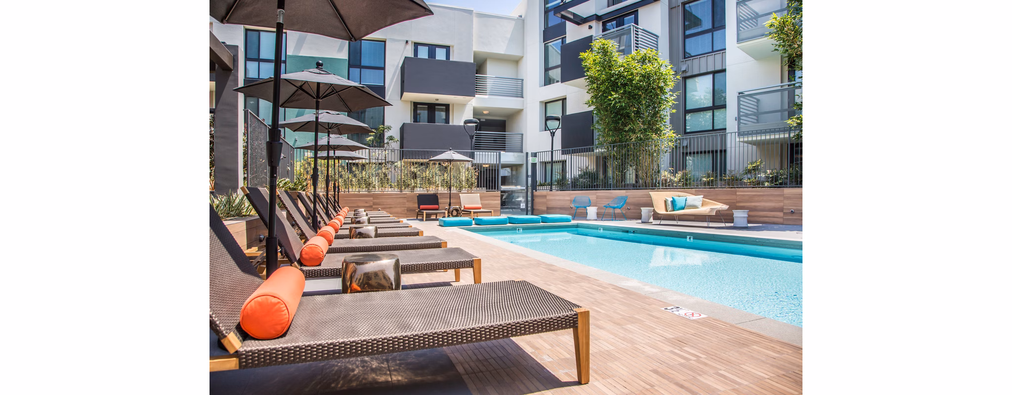Sunlit outdoor pool with lounge seating at Access Culver City Apartments