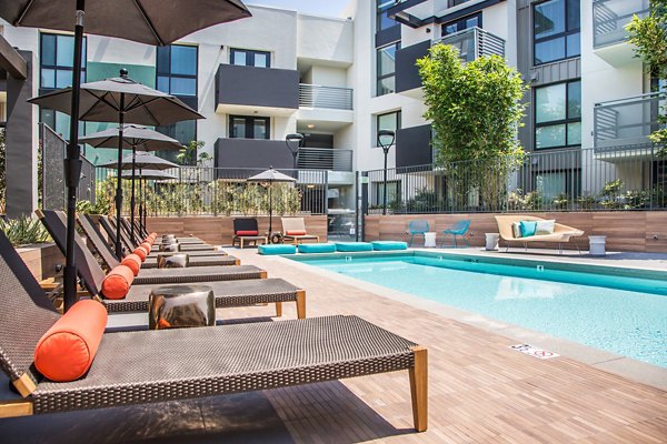Sunlit outdoor pool with lounge seating at Access Culver City Apartments