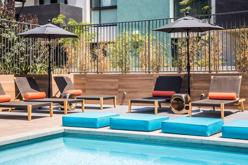 Rooftop pool with lounge chairs and city views at Access Culver City Apartments