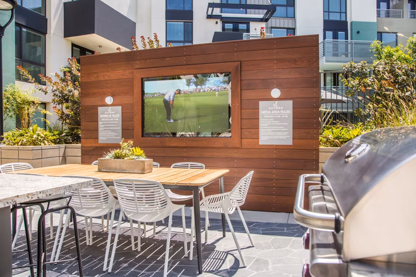 Outdoor patio with modern seating and lush greenery at Access Culver City Apartments