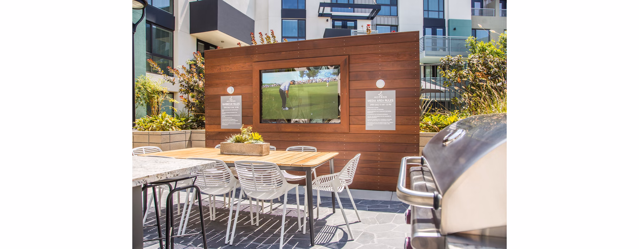 Outdoor patio with modern seating and lush greenery at Access Culver City Apartments