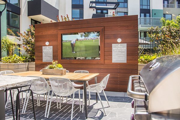 Outdoor patio with modern seating and lush greenery at Access Culver City Apartments