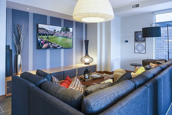 Clubhouse theater with plush seating and large screen at The Island Residences at Carlson Center Apartments