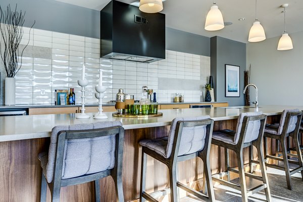 Clubhouse bar with modern seating and ambient lighting at The Island Residences at Carlson Center Apartments