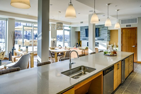 Clubhouse bar with modern seating and lighting at The Island Residences at Carlson Center Apartments