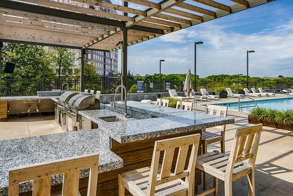 Spacious patio and grill area at The Island Residences at Carlson Center Apartments, ideal for outdoor gatherings and relaxation