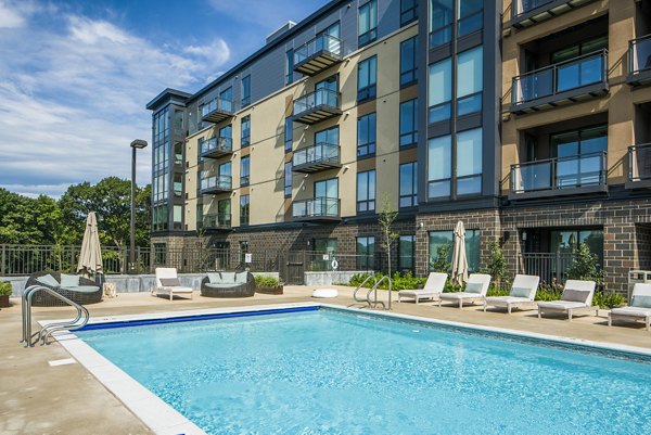 Resort-style pool with lounge chairs at The Island Residences at Carlson Center Apartments