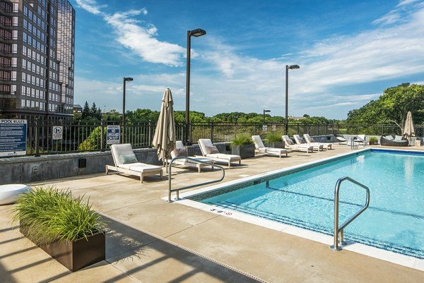 Resort-style pool with sun loungers at The Island Residences at Carlson Center Apartments