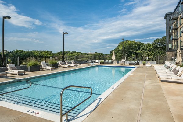 The Island Residences: Serene waterfront apartments at Carlson Center with lush landscaping and reflective pond