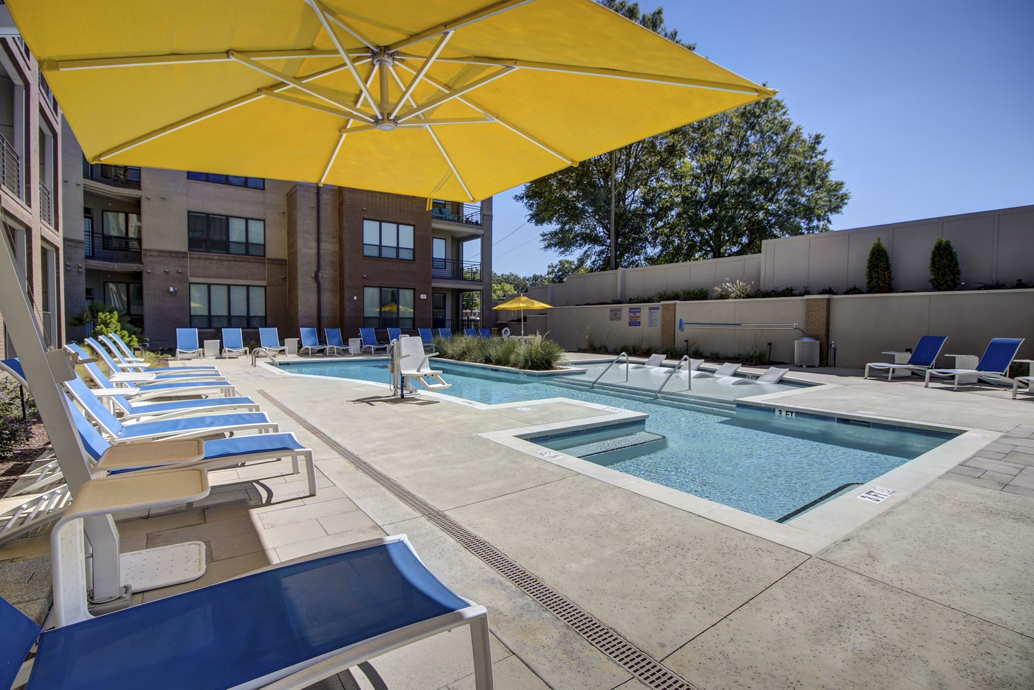 Resort-style pool surrounded by lush landscaping at 810 NINTH Apartments luxury community