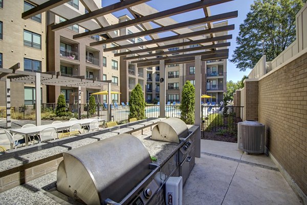 Outdoor grill area with modern seating at 810 NINTH Apartments