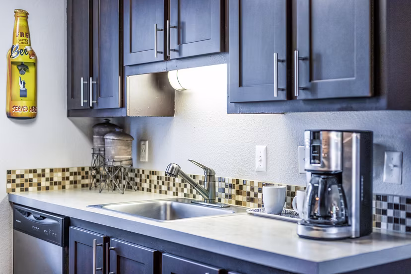 Modern kitchen with stainless steel appliances and marble countertops in The Alden Apartments