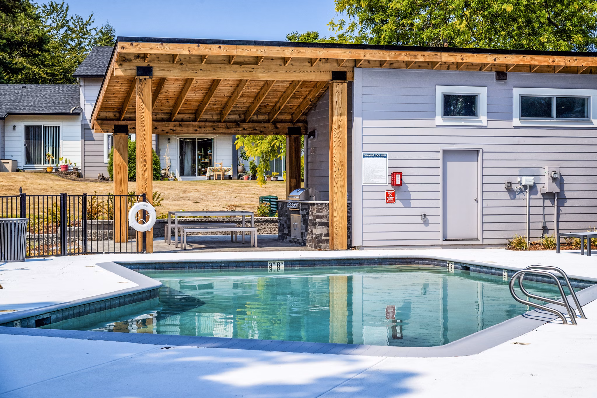 Luxury pool with lounge chairs at The Alden Apartments offering resort-style amenities for residents