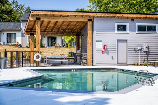 Luxury pool with lounge chairs at The Alden Apartments offering resort-style amenities for residents