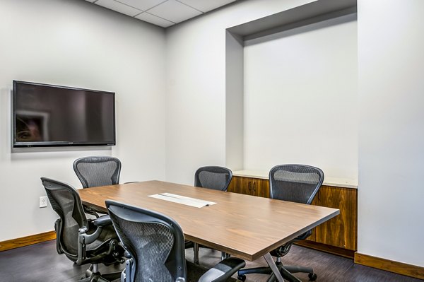 Modern conference room with seating and AV technology at 2116 Chestnut Apartments, ideal for meetings and events