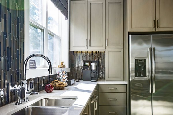 Modern kitchen with stainless steel appliances and granite countertops in Residences at Brookline Apartments