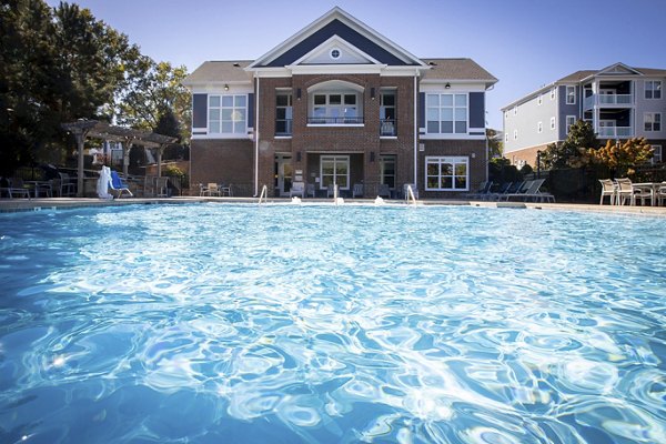 Modern outdoor pool area at Residences at Brookline Apartments, featuring comfortable lounge seating and lush landscaping for relaxation and enjoyment