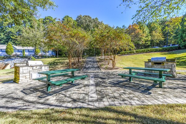 Grill area patio at Avana Kennesaw Apartments in luxury setting, ideal for outdoor dining and socializing with modern seating and lush landscaping