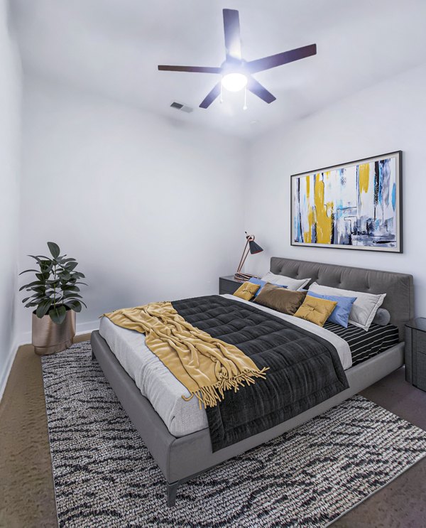 Elegant bedroom with modern furnishings and large windows at Presley Uptown Apartments