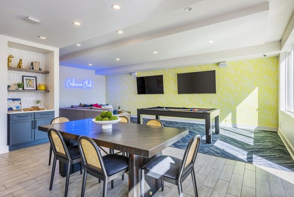 Clubhouse game room with billiards table and lounge seating at Presley Uptown Apartments