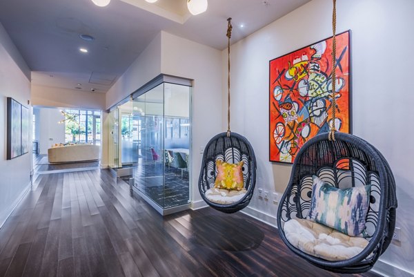 Clubhouse lobby with contemporary decor and seating at Presley Uptown Apartments