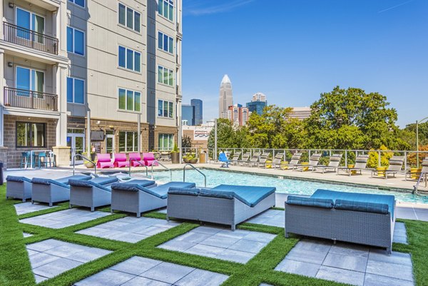 Inviting outdoor pool area with loungers at Presley Uptown Apartments, a luxury Greystar community