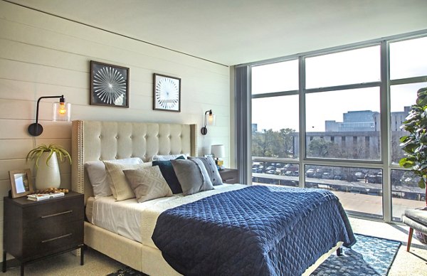 Elegant bedroom with natural light and modern decor at The Cabochon at River Oaks Apartments