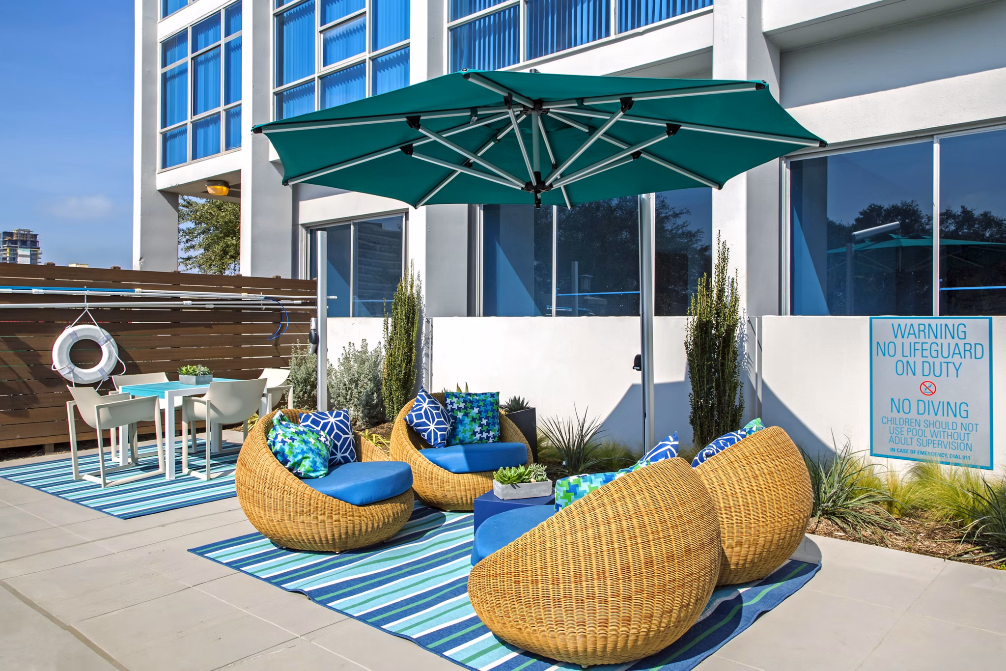 Sundeck with plush seating and lush greenery at The Cabochon at River Oaks Apartments