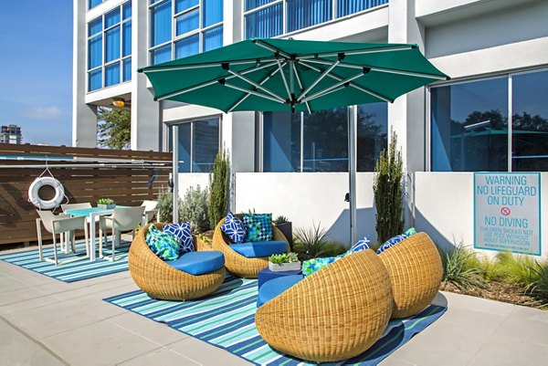 Sundeck with plush seating and lush greenery at The Cabochon at River Oaks Apartments