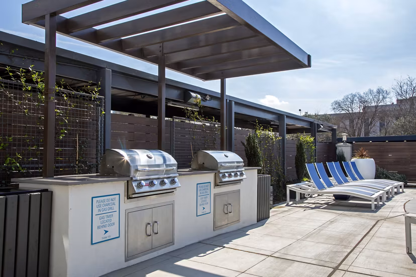Outdoor grill area with modern seating at The Cabochon at River Oaks Apartments