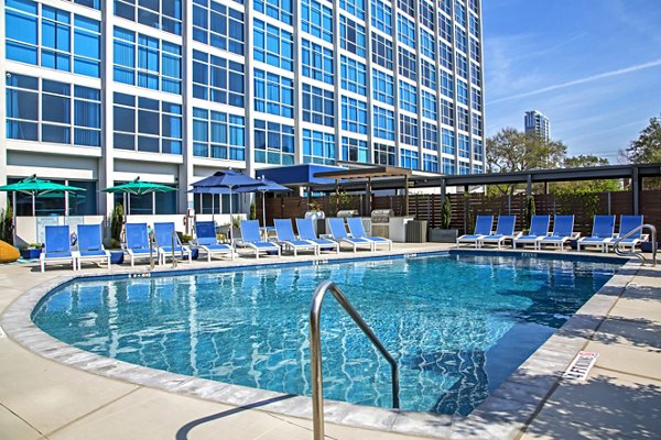 Luxurious pool with lounge chairs at The Cabochon at River Oaks Apartments, perfect for relaxation and socializing in a serene setting