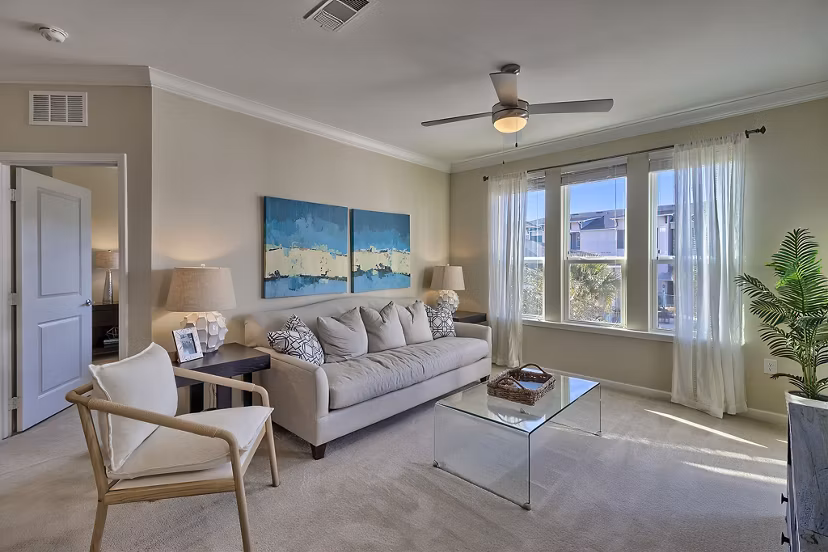 Living room with modern decor and large windows at Atlantic at Parkridge Apartments, a luxury Greystar property in a vibrant community