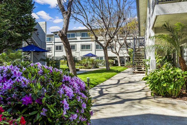 Courtyard featuring lush landscaping and seating areas at Madrid Apartments