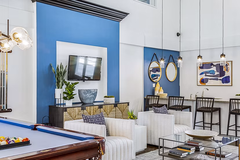 Modern clubhouse with game room at Madrid Apartments, featuring pool tables and lounge areas for luxury relaxation and entertainment