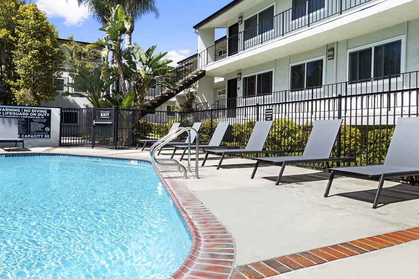 Outdoor swimming pool with cozy lounge chairs at Madrid Apartments, a Greystar luxury community in a vibrant neighborhood