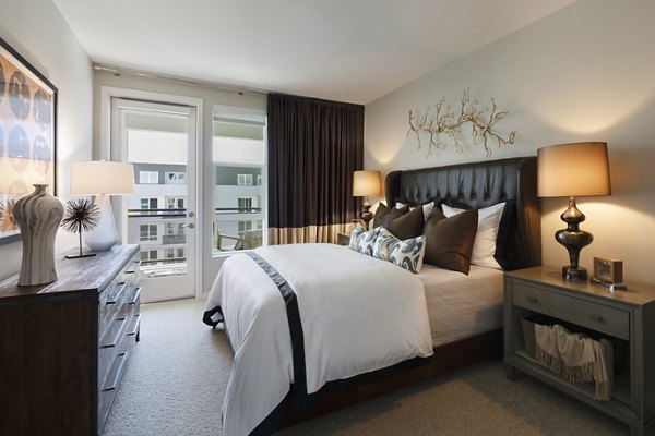 Cozy bedroom with modern decor in Altana Apartments featuring ample natural light and spacious layout