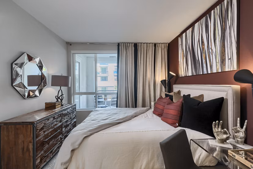 Spacious bedroom with modern decor in Altana Apartments, featuring large windows and neutral tones