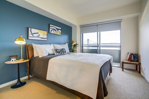 Bedroom with elegant decor and large windows at The Towers at Rincon Apartments offering luxury living in San Francisco