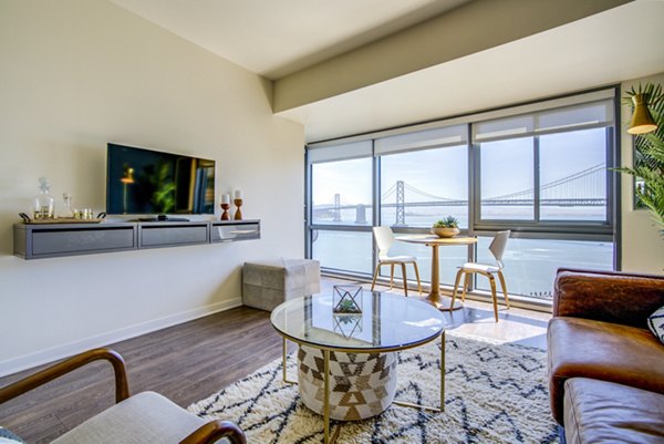 Living room with modern furnishings and skyline views at The Towers at Rincon Apartments