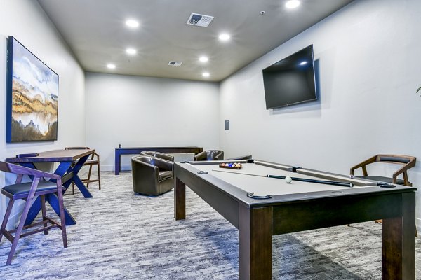 Clubhouse game room featuring billiards and seating areas at Arbors at Antelope Apartments
