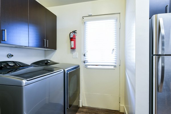 Laundry room equipped with modern washers and dryers at Arbors at Antelope Apartments, offering convenience and efficiency for residents