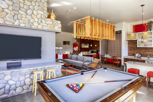 Game room with pool table and large screen TVs at RockVue Apartments in Broomfield, CO