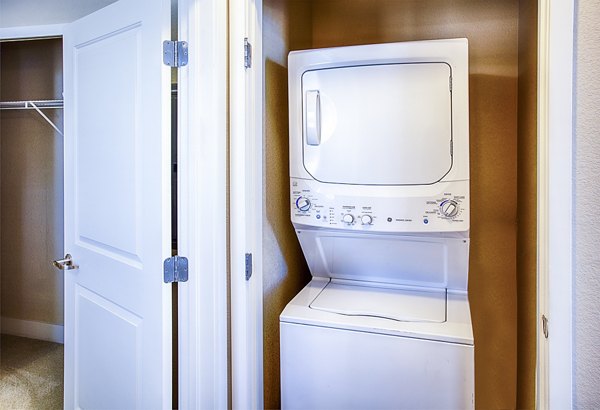 Modern laundry room with stainless-steel appliances at RockVue Apartments