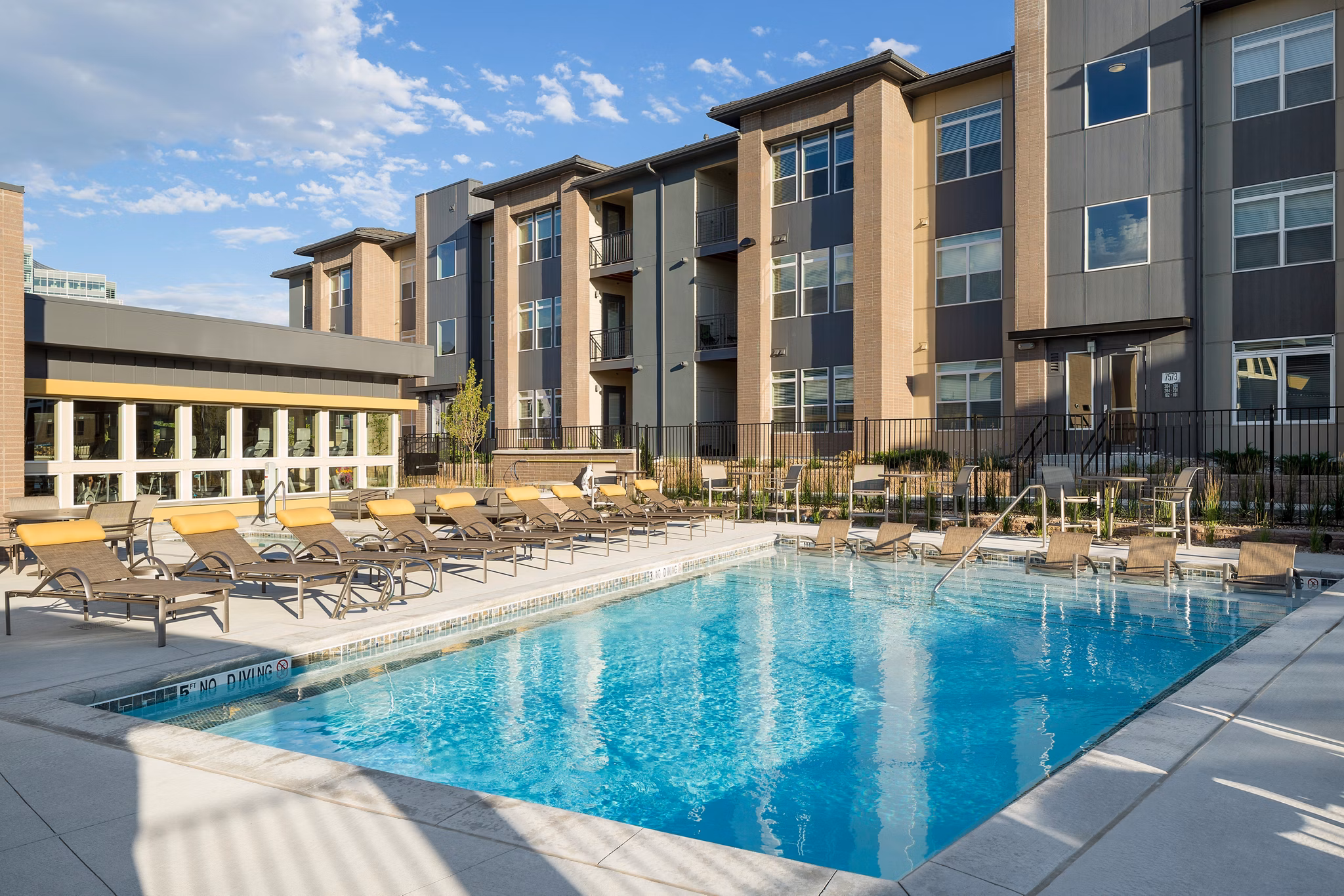 Poolside relaxation at Pearl DTC Apartments featuring a luxury pool area surrounded by stylish loungers and lush landscaping
