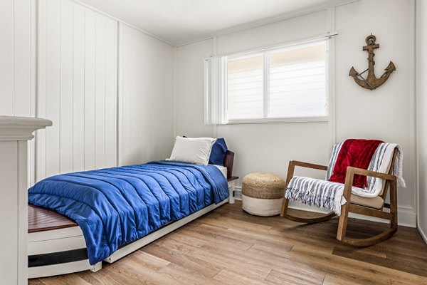 Modern bedroom featuring coastal decor and large windows in Kapilina Beach Homes Apartments, offering a serene living experience near the beach